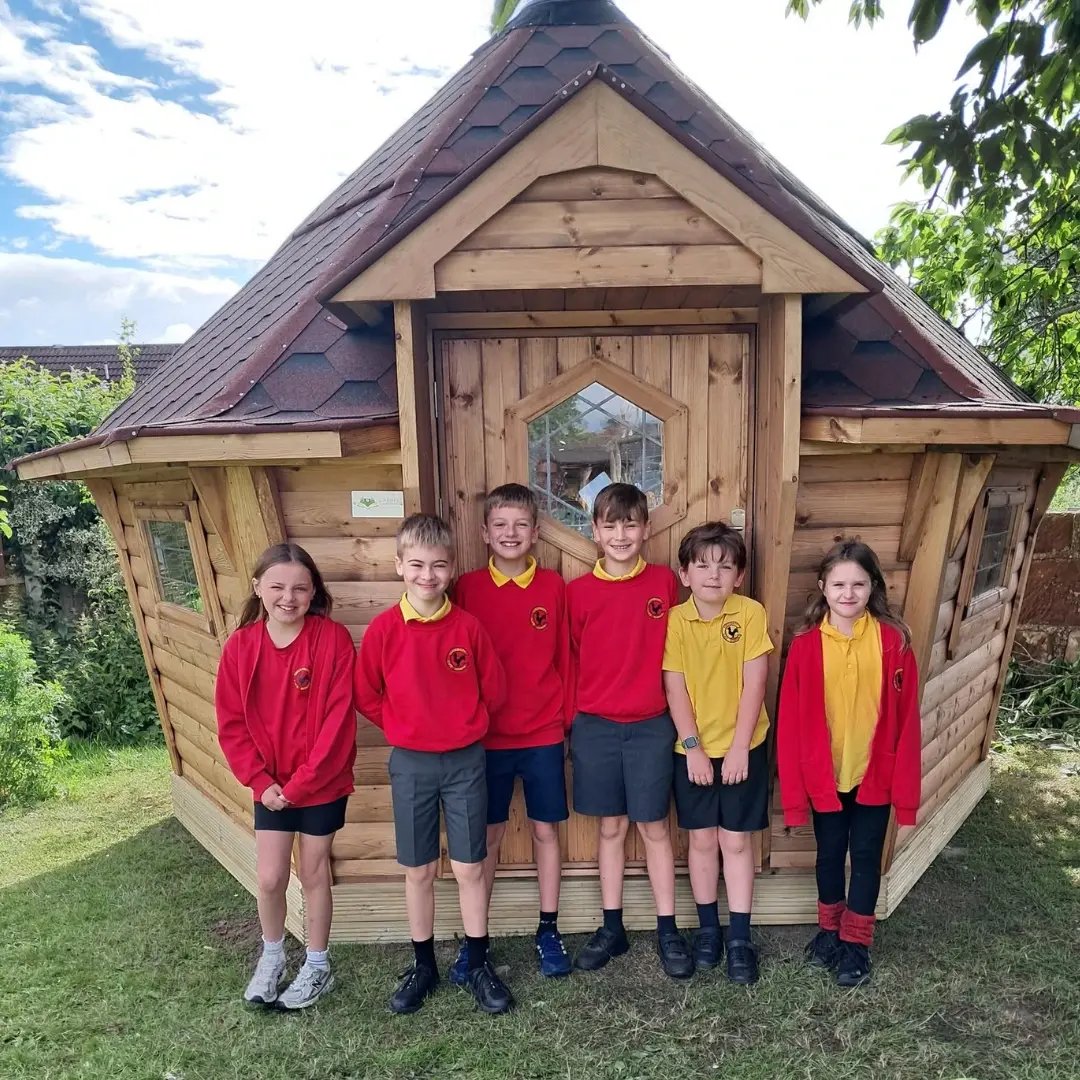 children outside their new log cabin
