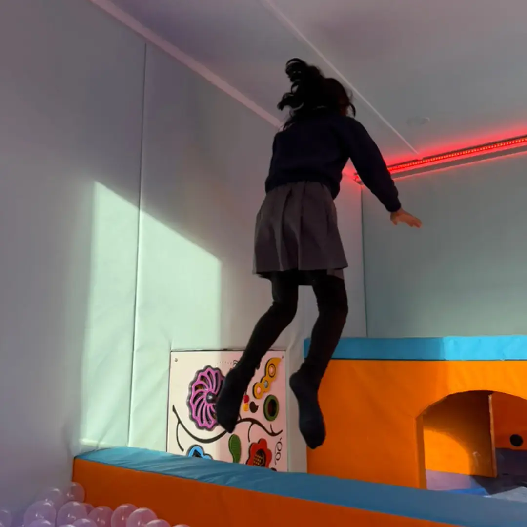 child jumping into ball pit